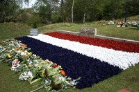 Bloemen bij het monument op de Waalsdorpervlakte. / Bron: -JvL- from Netherlands, Wikimedia Commons (CC BY-2.0)